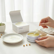 Hand lifting Mixsoon Bean Hydrogel Eye Patch from jar during skincare application